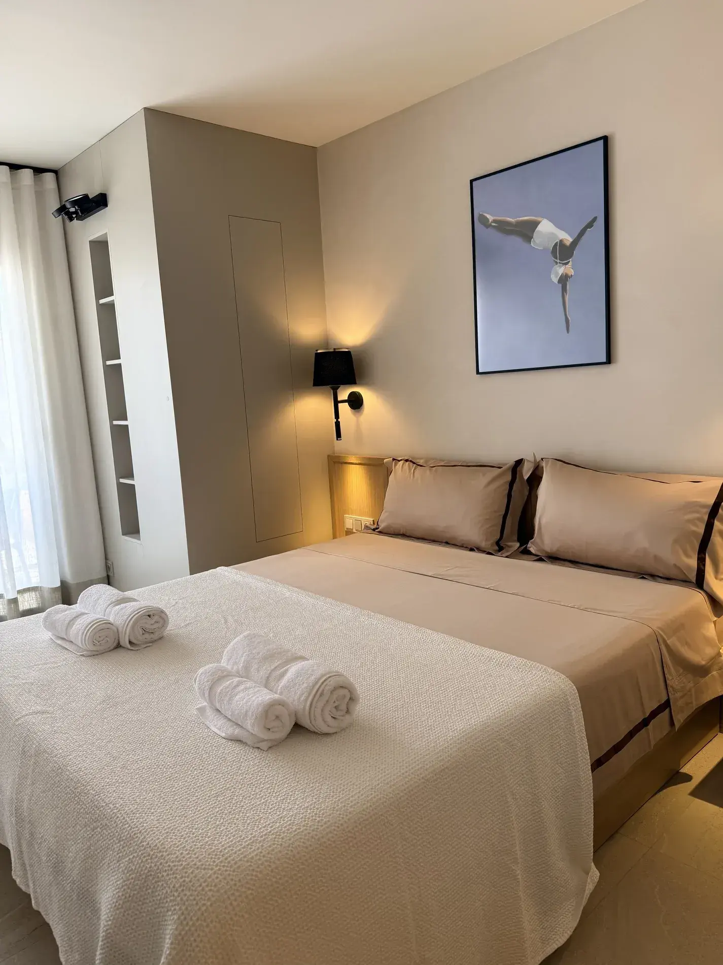 Dormitorio de invitados con apliques negros y cuadro