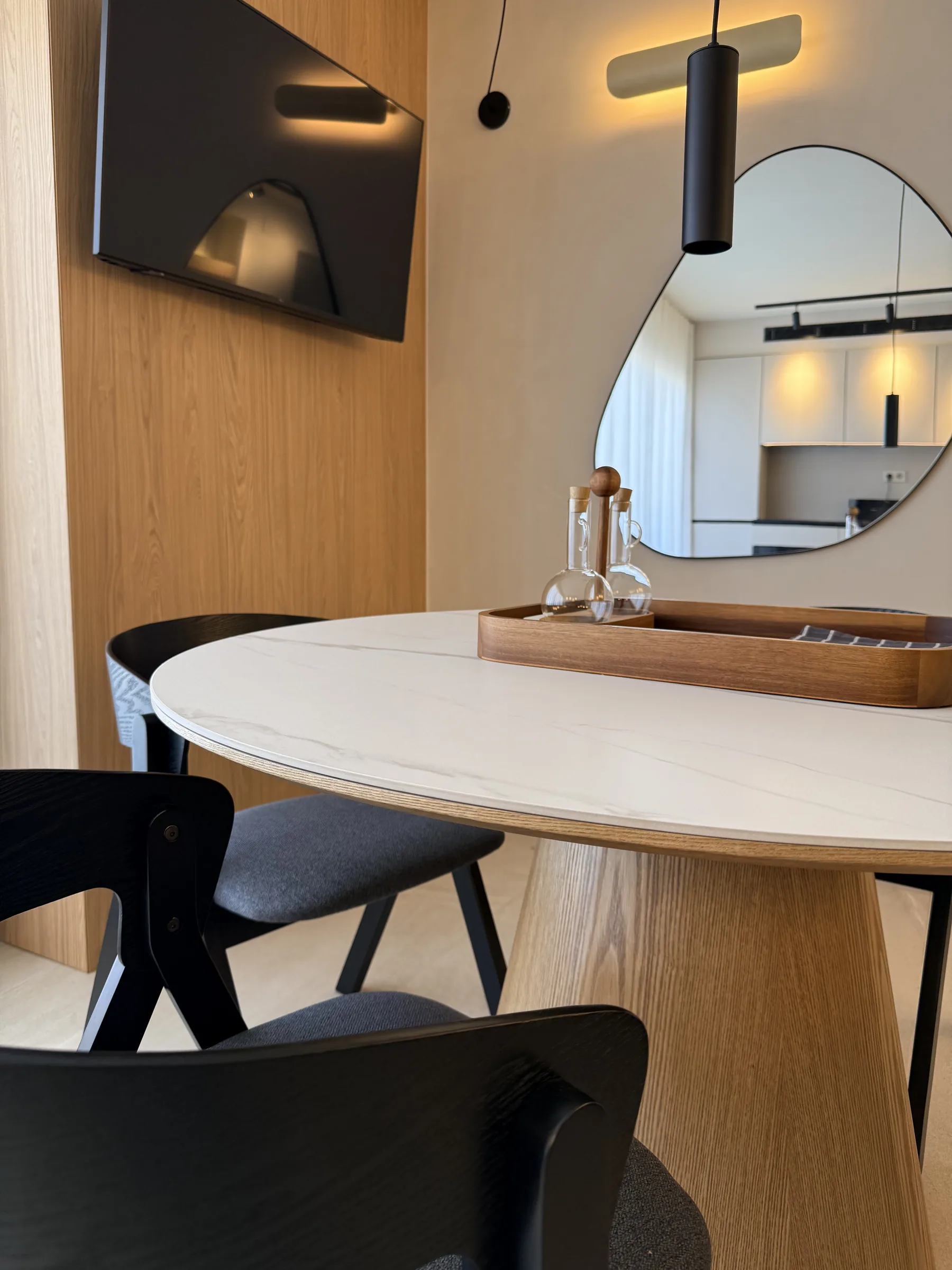 Detalle del comedor con lámpara colgante y reflejo de la cocina